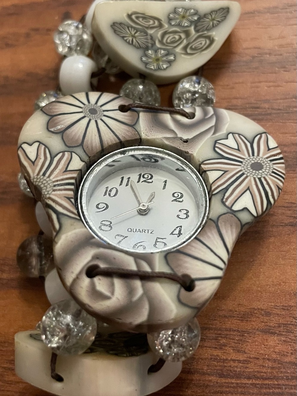 vintage decorative watch featuring a floral pattern casing and beaded bracelet